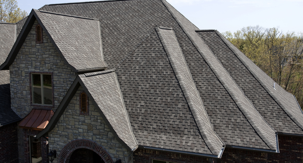 Stone facade building with complex roofline and shingles